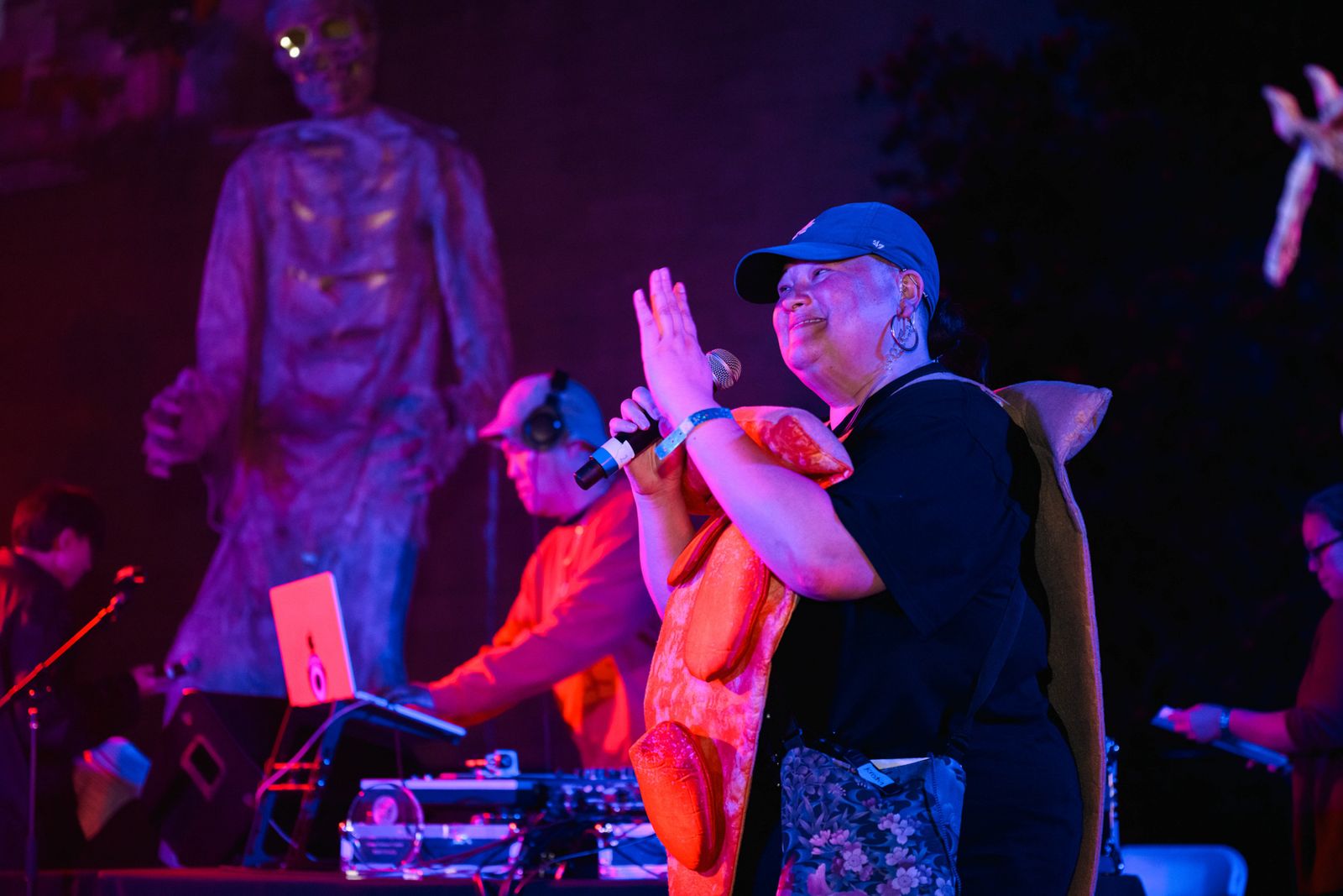MC on stage with DJ and skeleton decoration under purple lights